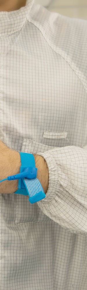 A man wearing an ESD smock demonstrating it's ESD capability